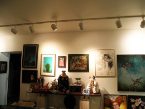 A wall in my office at home (the ceiling track lights are on all sides of the room where paintings hang)  